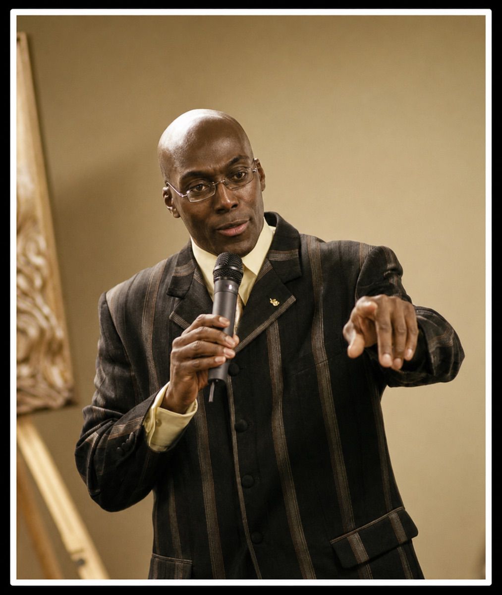 Donald Brown presenting beside a sculpture